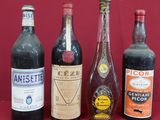 Plusieurs bouteilles de vin sont alignées sur une surface rouge