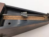 a wooden box with a ruler on it on a table