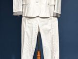 a white suit on a mannequin stand against a blue wall
