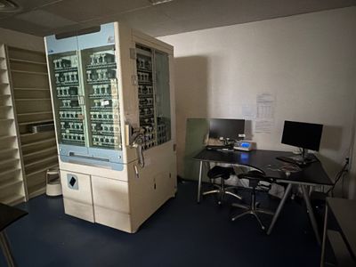 un distributeur automatique au milieu d'une pièce équipée d'un bureau et de chaises