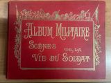 an old red album with gold lettering on a wooden table