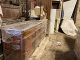 a wooden dresser in the middle of a room covered in plastic