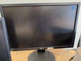 a computer monitor sitting on a desk next to a keyboard