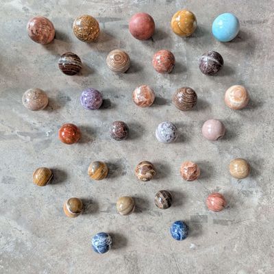 a lot of different colored marbles on the floor