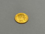 a close up of a gold coin on a gray surface