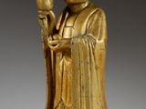 an image of a gold statue of a person holding a flower