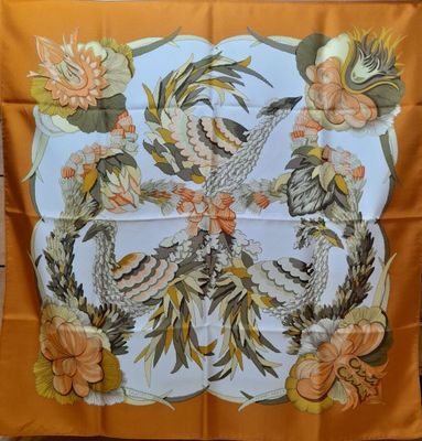 une écharpe orange et blanche ornée d'un oiseau et de fleurs