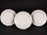 three white plates are sitting on top of a black surface