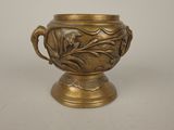 a gold vase that is sitting on a table