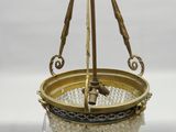 une assiette en or suspendue au plafond au-dessus d'une table blanche