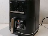 a black air fryer sitting on a counter top