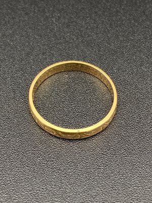 gros plan d'une bague en or sur une surface noire
