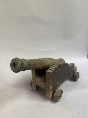 un petit canon en bois posé à côté d'un autre canon en bois, plus petit