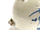 a white vase with blue designs on it on a white surface