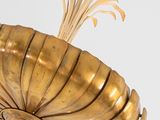 a gold sculpture of a shell on a white surface