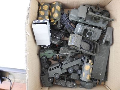 a cardboard box filled with toy army vehicles and a cell phone