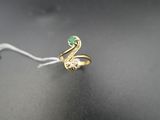 une bague en or avec une pierre verte au centre