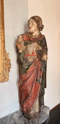 une statue représentant un homme debout près d'un miroir dans une pièce