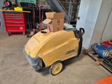 une machine qui se trouve dans le garage, avec des cartons posés dessus