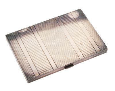 un étui à cigarettes en argent posé sur une table blanche
