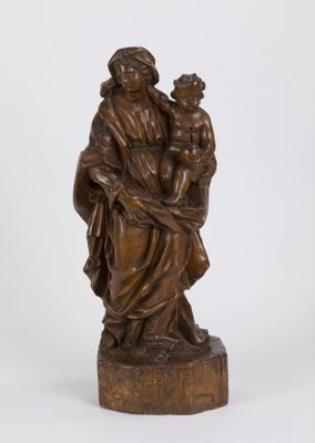 une statue antique en bronze représentant une femme tenant un enfant dans ses bras