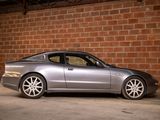 a silver sports car parked in front of a brick wall