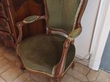 a green chair sitting in front of a dresser in a room