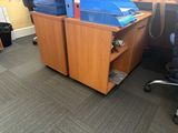 a desk with two bins and a chair in the corner