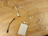 une photo d'une table sur laquelle se trouvent un chargeur, un casque et des câbles