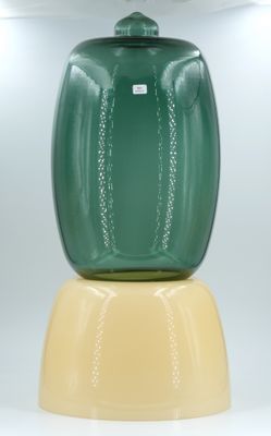 a green vase sitting on top of a yellow base