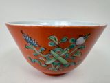 un bol orange orné de motifs bleus et blancs