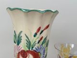 a vase and a glass sitting on a table