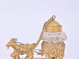 a gold figurine of a horse pulling a carriage with a man on it