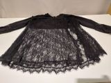 black lace dress with long sleeves on a white table