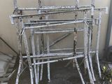 a pile of old metal frames sitting outside of a building