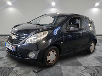 the small black car is parked on a checkered tile floor