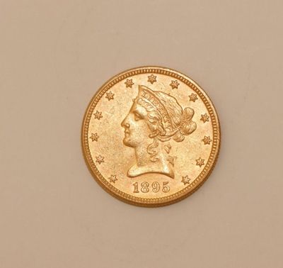 a close up of a gold coin with a woman ' s head on it