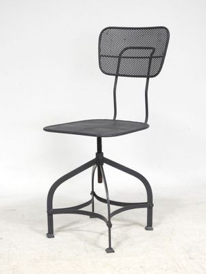 une chaise en métal noir avec un dossier en résille et un repose-pieds