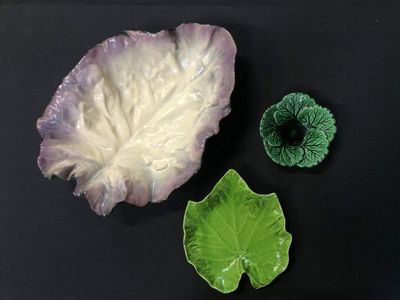 a cabbage and a cabbage leaf on a black surface
