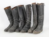 quatre paires de bottes sont alignées sur une surface blanche