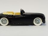a black toy car with a yellow top and white wheels