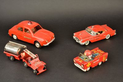 quatre petites voitures et un camion de pompiers posés sur une surface noire