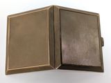 a small metal box with a brown cover on a white surface