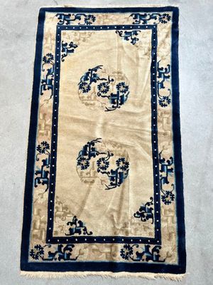 an antique chinese rug with a blue border and a white background