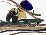 Plusieurs paires de chaussures, des ceintures et un chapeau sont disposés sur une surface blanche