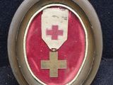 une photo d'une médaille sur laquelle figure une croix rouge