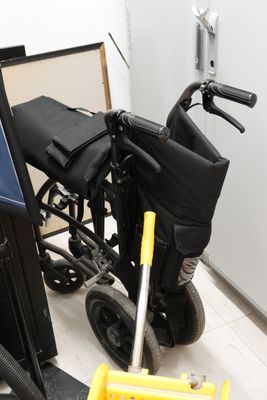 un fauteuil roulant qui se trouve dans une pièce, à côté d'une poubelle