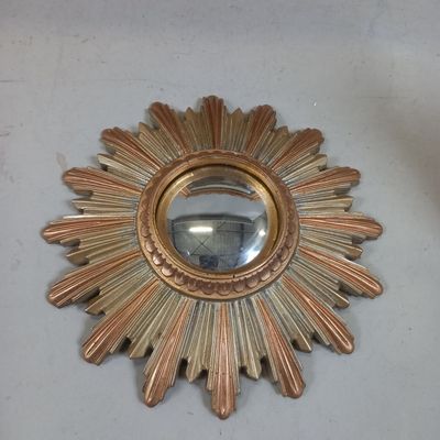 un soleil doré rayonnant, avec un miroir accroché au mur