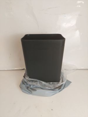 une poubelle noire posée sur un sac en plastique