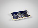 une petite assiette bleue et jaune décorée de fleurs